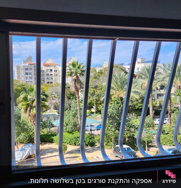 סורגי חלון לבנים עם נוף עצים ברקע